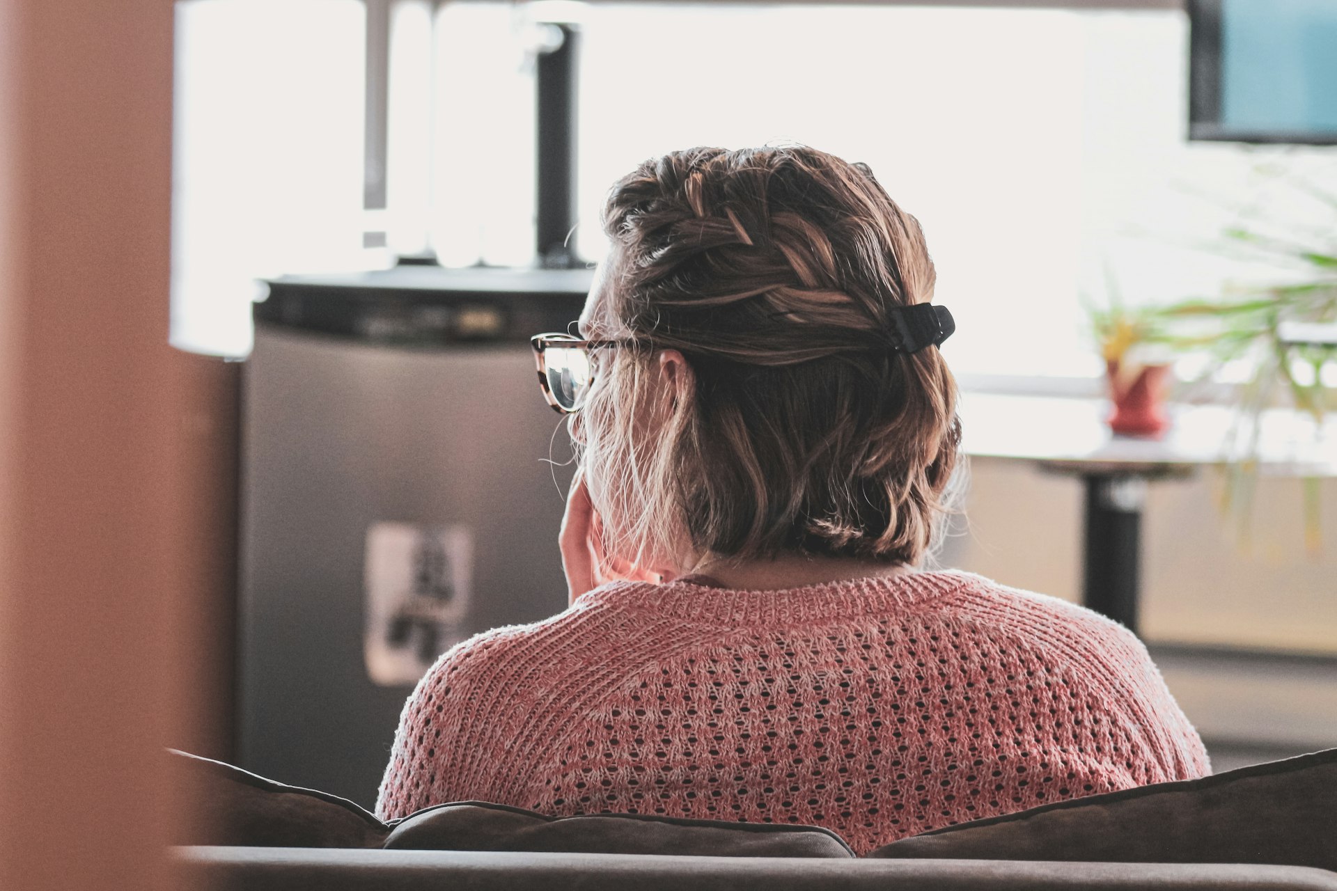 woman in red knit sweater wearing black framed eyeglasses